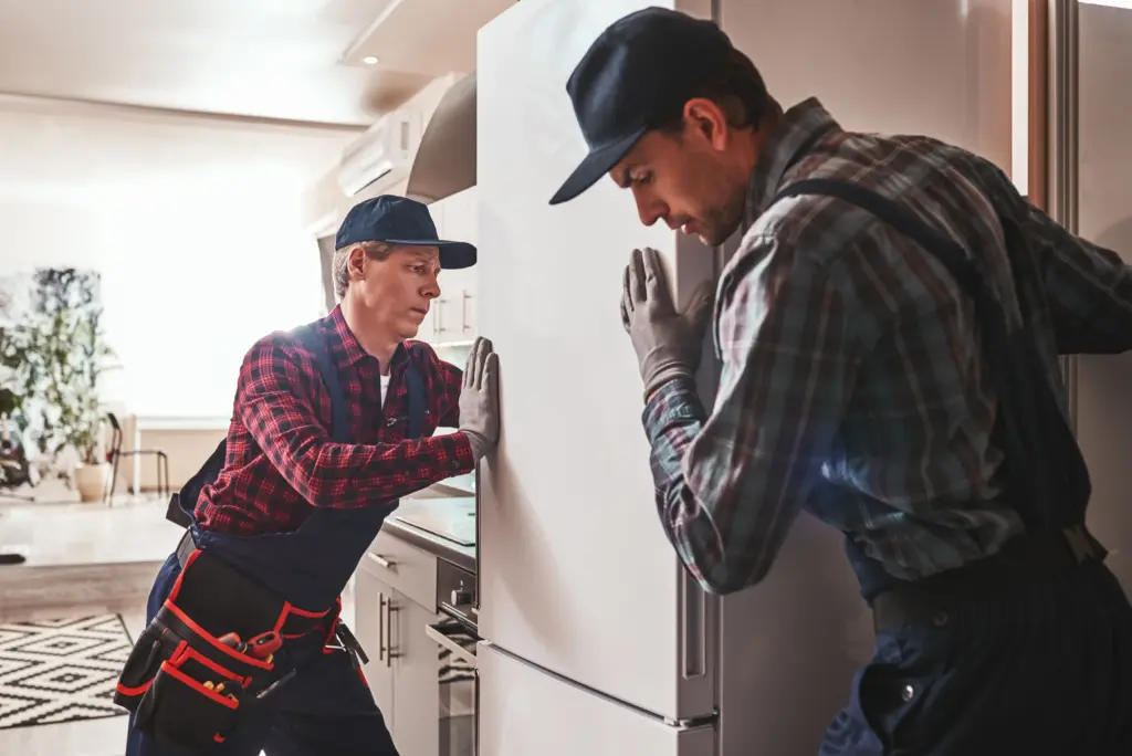 easy to solve young men mechanics checking refrigrator