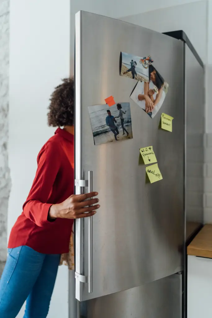 hungry woman standing in kitchen searching her freezer