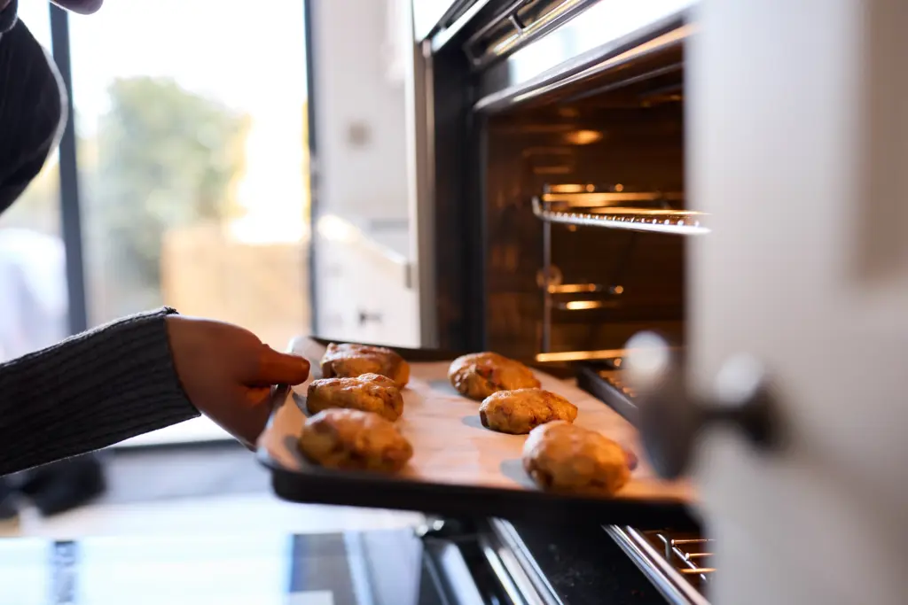 Are Microwave Ovens Bad for You close up of woman at home putting baking tray