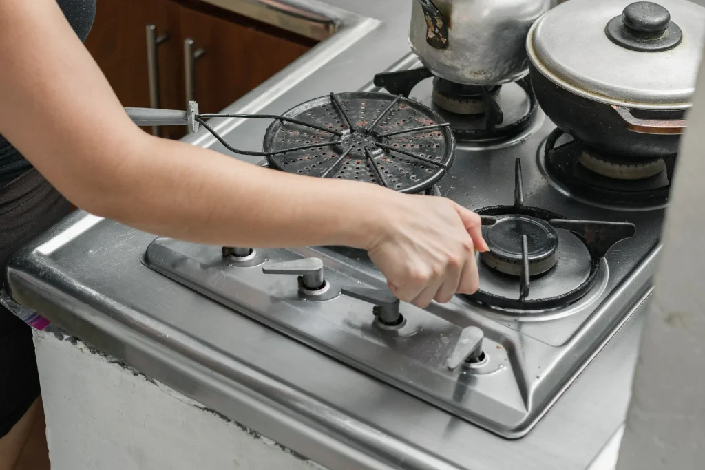 hand turning on a gas stove in kitchen 2026 09 23 19 41 46 utc