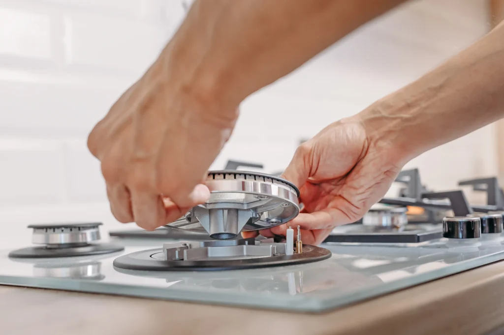 hands repairing a gas stove burner at home 2026 09 22 03 13 55 utc
