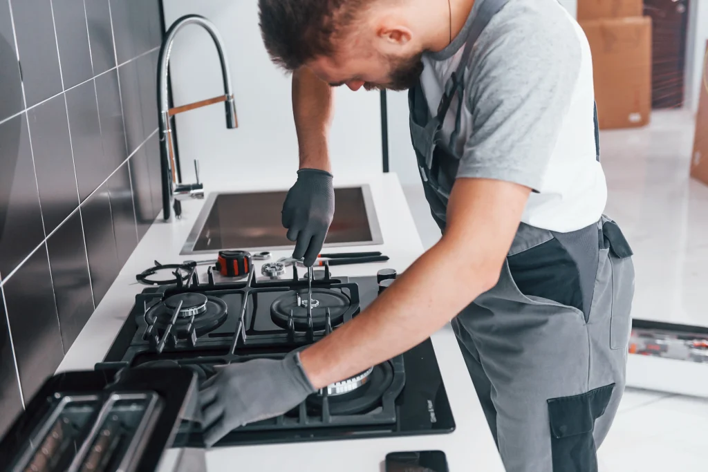 repairman fixing gas stove in modern kitchen 2026 09 22 02 56 43 utc